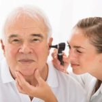 Doctor examining older mans ear for ear infections
