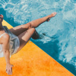 woman sunbathing next to a pool