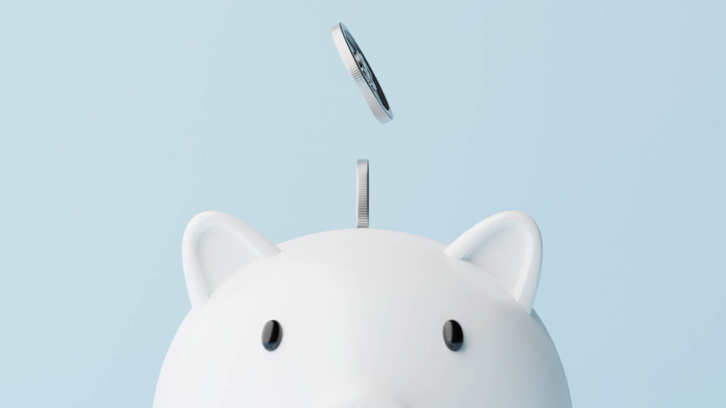 white piggy bank on a blue background with money dropping into it