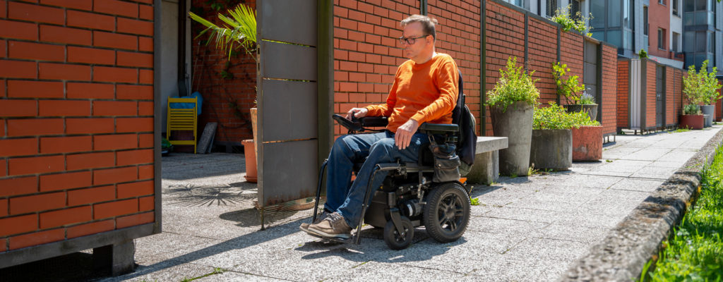 Older guy riding in motorized wheelchair 