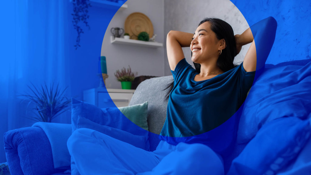 woman sitting on couch smiling and relaxing