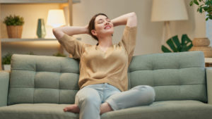 woman sitting on green couch enjoying clean air