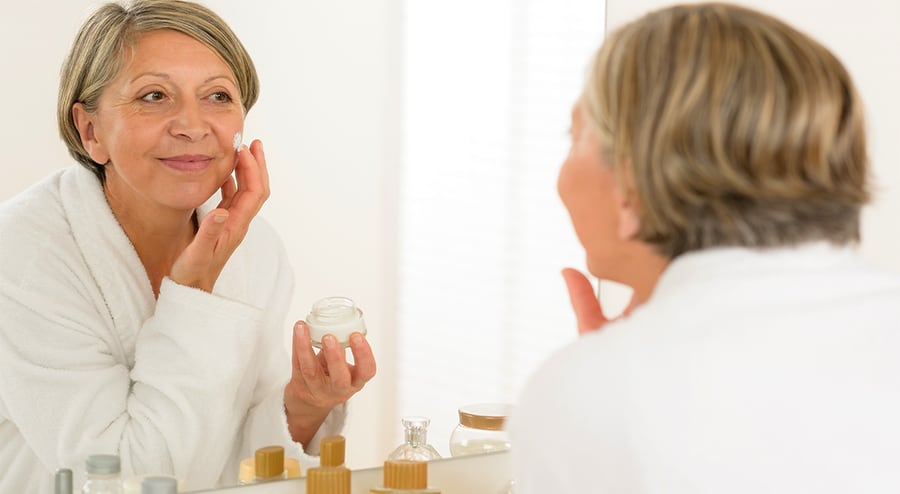 Older woman applying facial cream